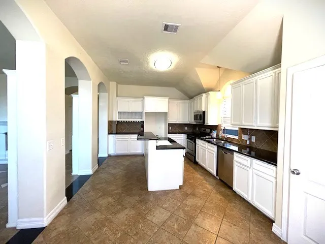 a kitchen with a sink and stainless steel appliances