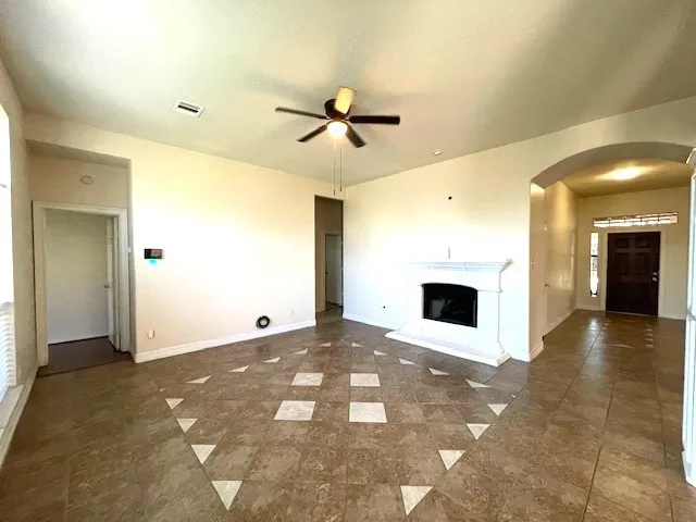 a view of a livingroom with a fireplace and a chandelier fan