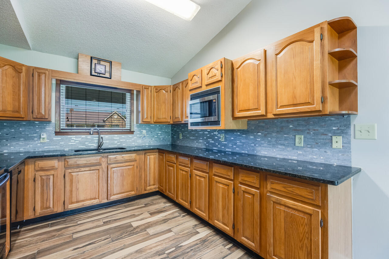 5811 Monroe Street Baker, FL 32531 - Photo 11 of 33 a kitchen with granite countertop a sink and cabinets