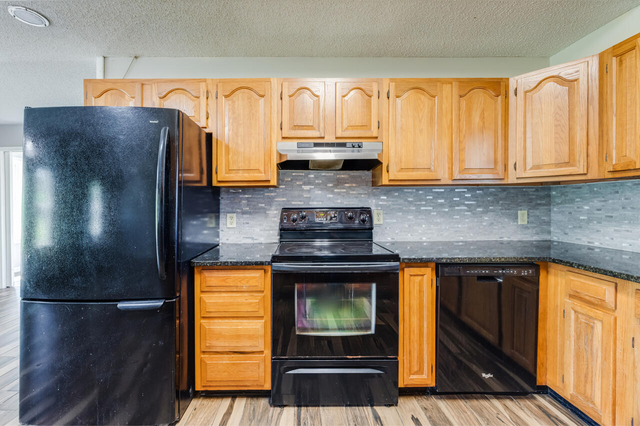 5811 Monroe Street Baker, FL 32531 - Photo 12 of 33 a kitchen with stainless steel appliances granite countertop a refrigerator and a stove