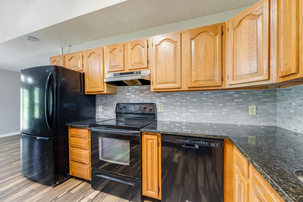 5811 Monroe Street Baker, FL 32531 - Photo 13 of 33 a kitchen with a sink a refrigerator and cabinets