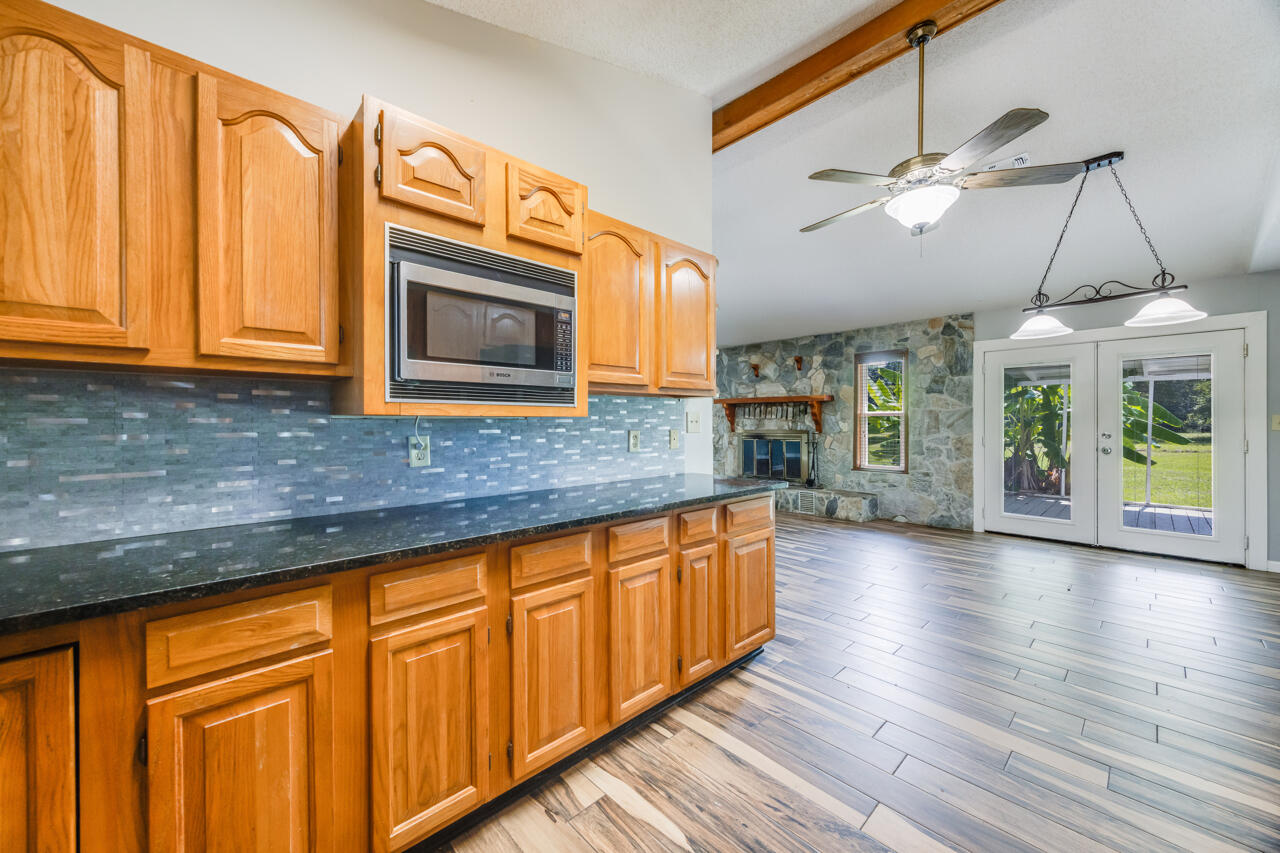 5811 Monroe Street Baker, FL 32531 - Photo 14 of 33 a kitchen with stainless steel appliances granite countertop cabinets and wooden floor
