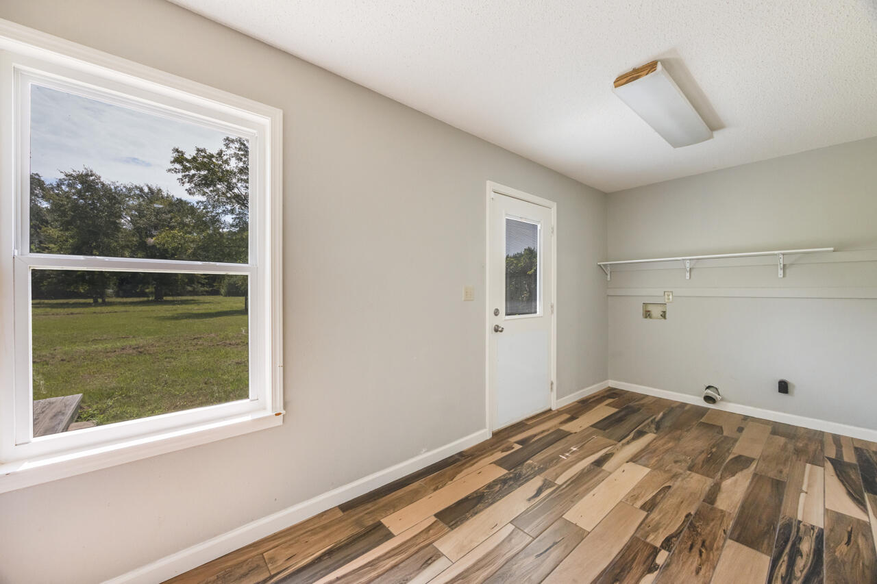 5811 Monroe Street Baker, FL 32531 - Photo 15 of 33 a view of a bedroom with wooden floor and a window