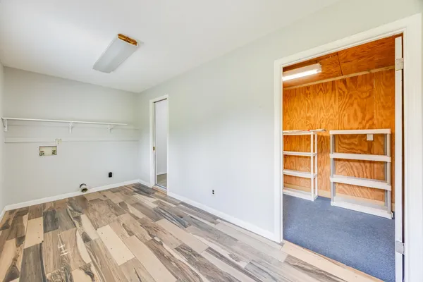 a view of empty room with wooden floor and cabinet