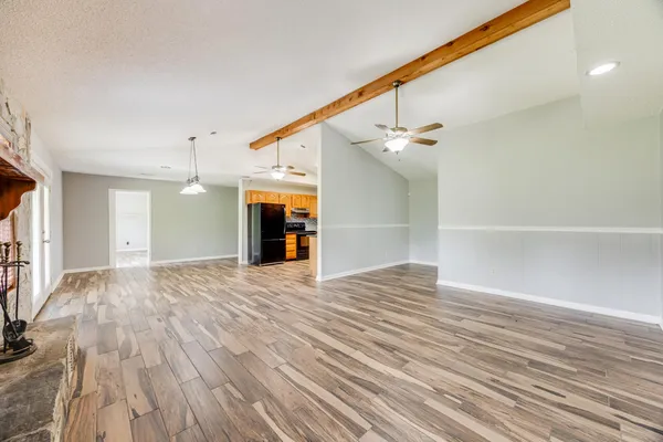 a view of empty room with wooden floor and fireplace