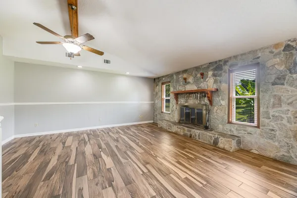 a view of an empty room with a fireplace and a window