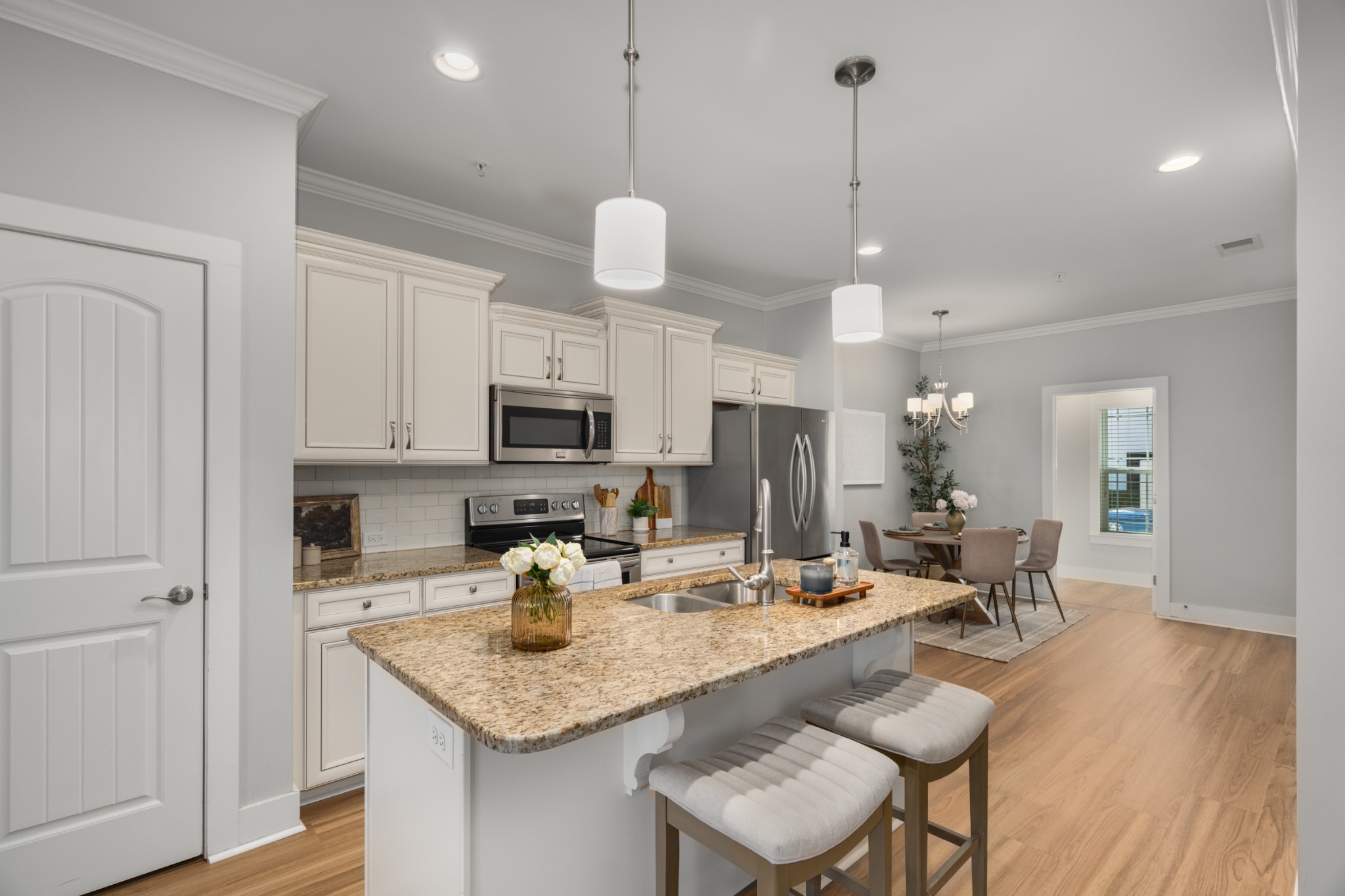 4021 Viola Lane Franklin, TN 37069 - Photo 11 of 34 a kitchen with stainless steel appliances kitchen island granite countertop a table chairs and a refrigerator