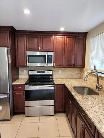 a kitchen with sink a microwave and refrigerator