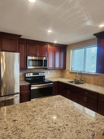 a kitchen with a sink stove and refrigerator