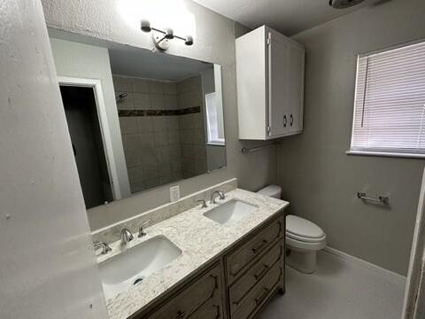 4408 Chicago Avenue Lubbock, TX 79414 - Photo 16 of 19 a bathroom with a granite countertop sink toilet and a mirror