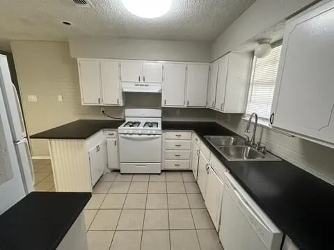 a kitchen with a sink a stove a microwave and cabinets
