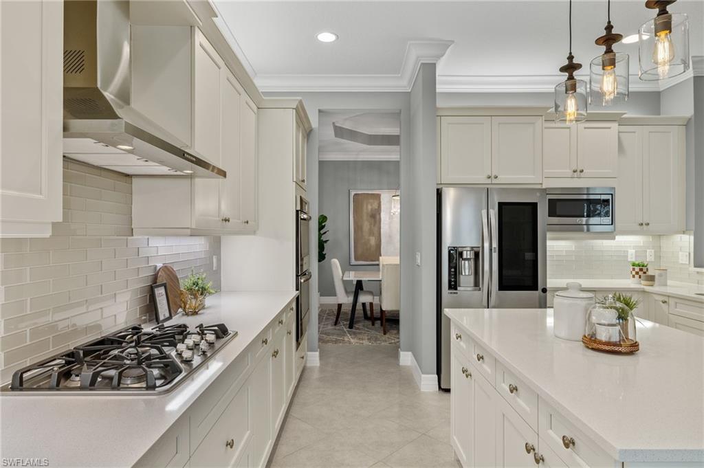 4398 Caldera Circle Naples, FL 34119 - Photo 14 of 50 a kitchen with stainless steel appliances granite countertop a stove and cabinets