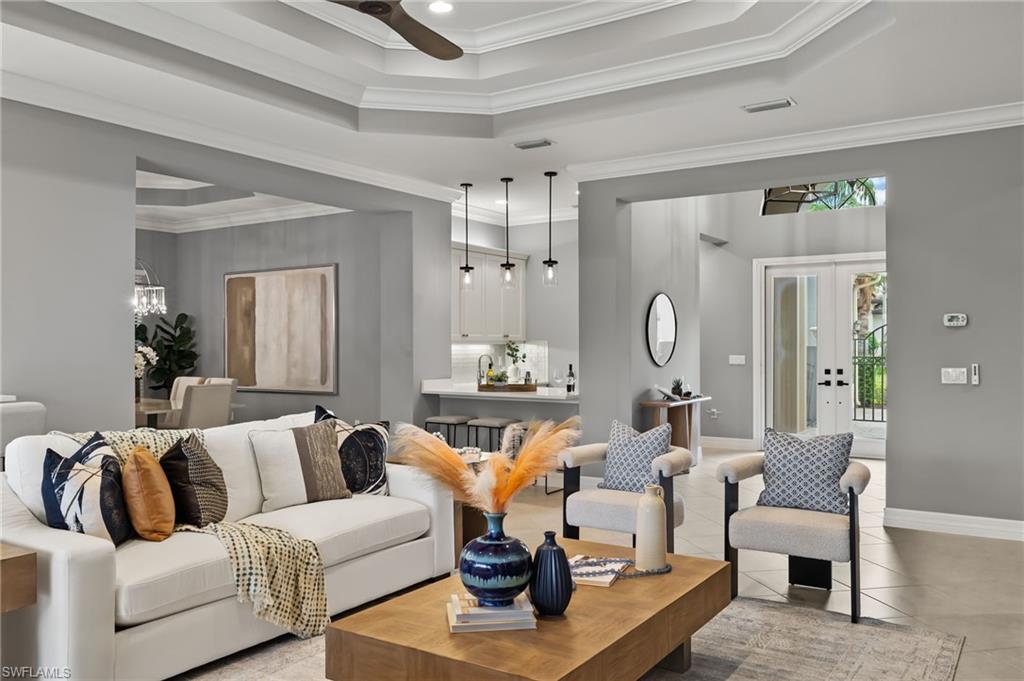 4398 Caldera Circle Naples, FL 34119 - Photo 18 of 50 a living room with furniture white walls and a chandelier