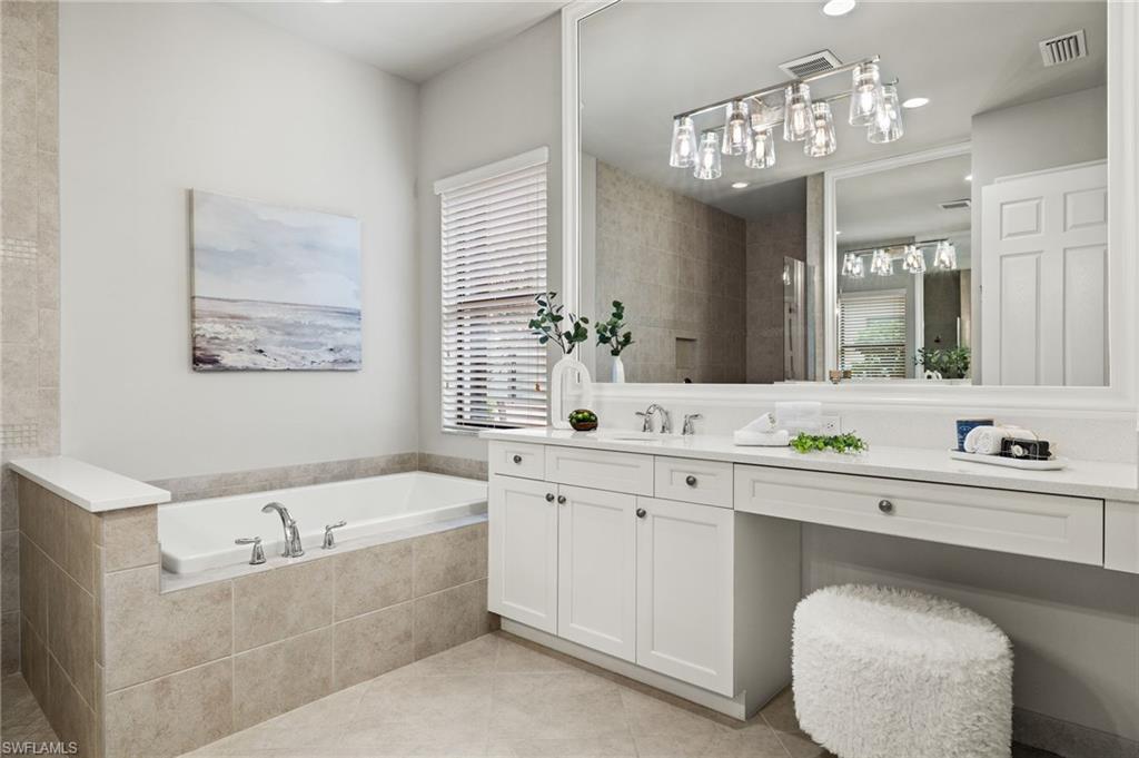 4398 Caldera Circle Naples, FL 34119 - Photo 31 of 50 a spacious bathroom with a sink a large mirror and a bathtub