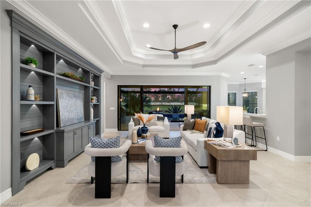 4398 Caldera Circle Naples, FL 34119 - Photo 4 of 50 a living room with furniture a chandelier and a fireplace