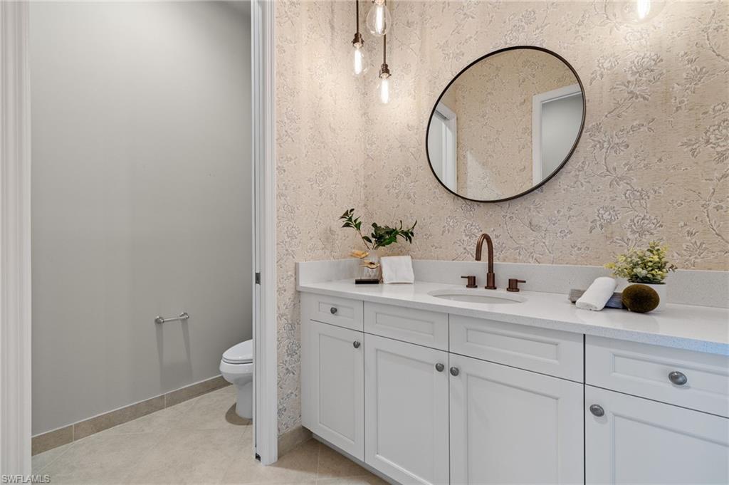 4398 Caldera Circle Naples, FL 34119 - Photo 41 of 50 a bathroom with a toilet a sink and a mirror
