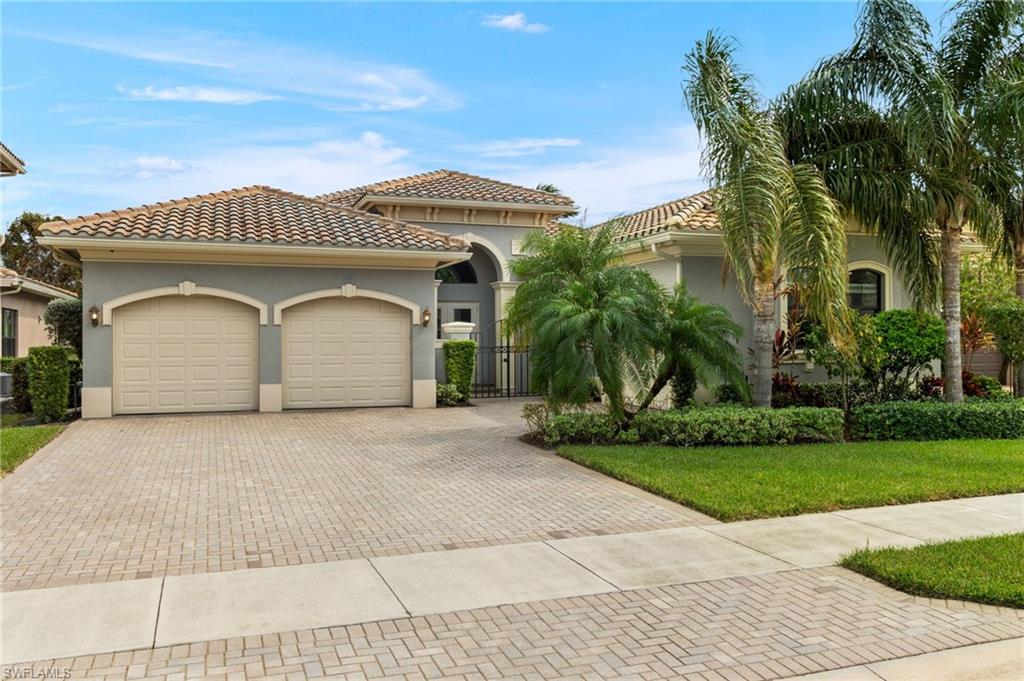 4398 Caldera Circle Naples, FL 34119 - Photo 10 of 50 a front view of a house with a garden and palm trees