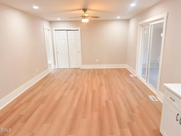 a view of an empty room with wooden floor