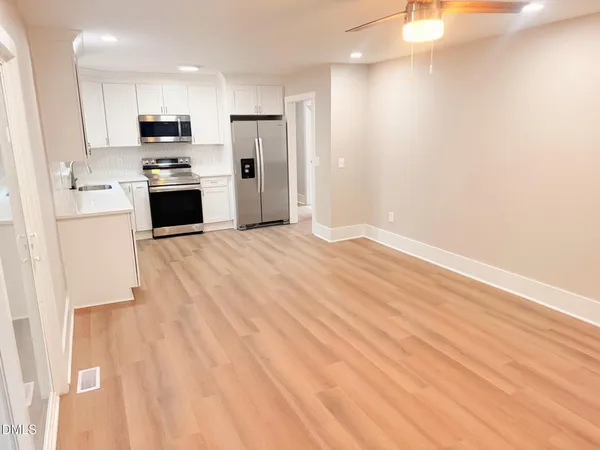 a view of kitchen with wooden floor and electronic appliances
