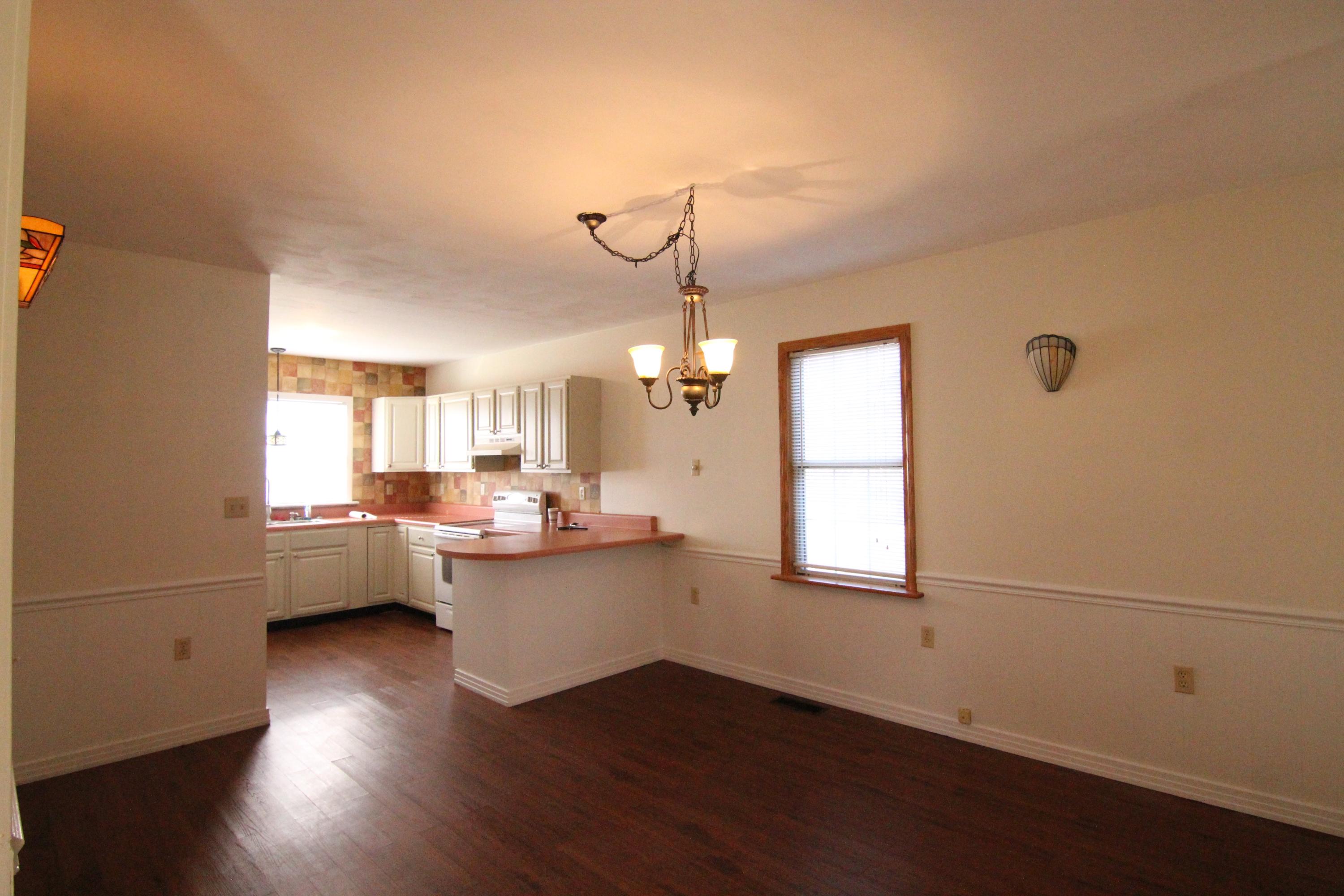 1063 Pep Hill Road Goodview, VA 24095 - Photo 11 of 27 a living room with couches a coffee table and wooden floor
