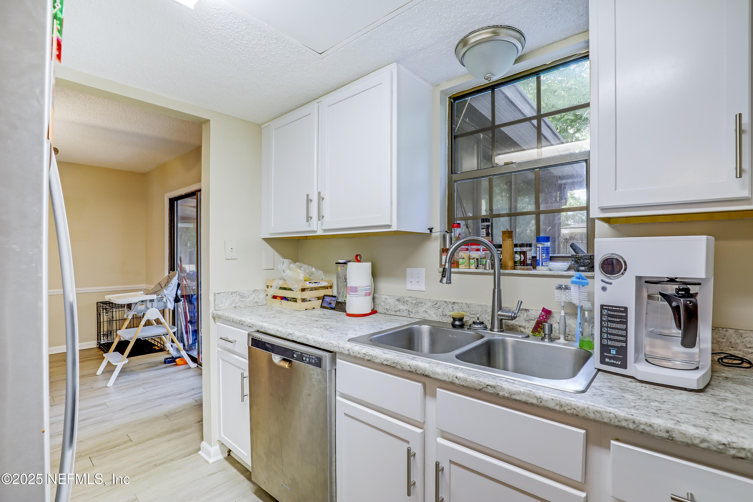 503 Kettering Way Orange Park, FL 32073 - Photo 16 of 28 a kitchen with stainless steel appliances granite countertop a sink dishwasher a stove and a dining table with cabinets