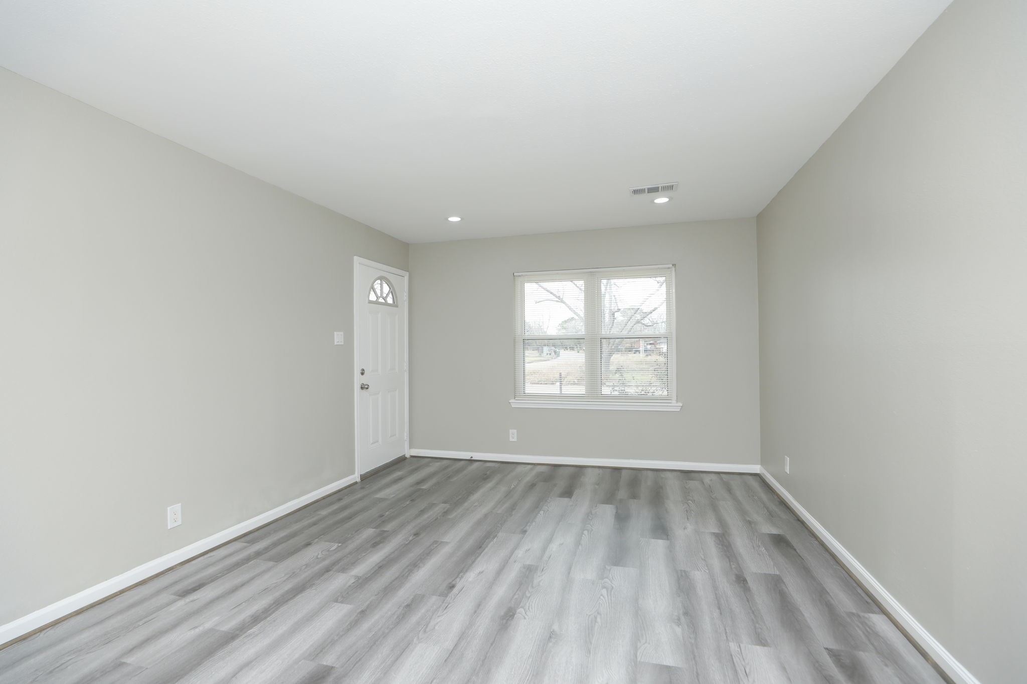 9211 Vinearbor Street Houston, TX 77033 - Photo 19 of 33 an empty room with wooden floor and windows