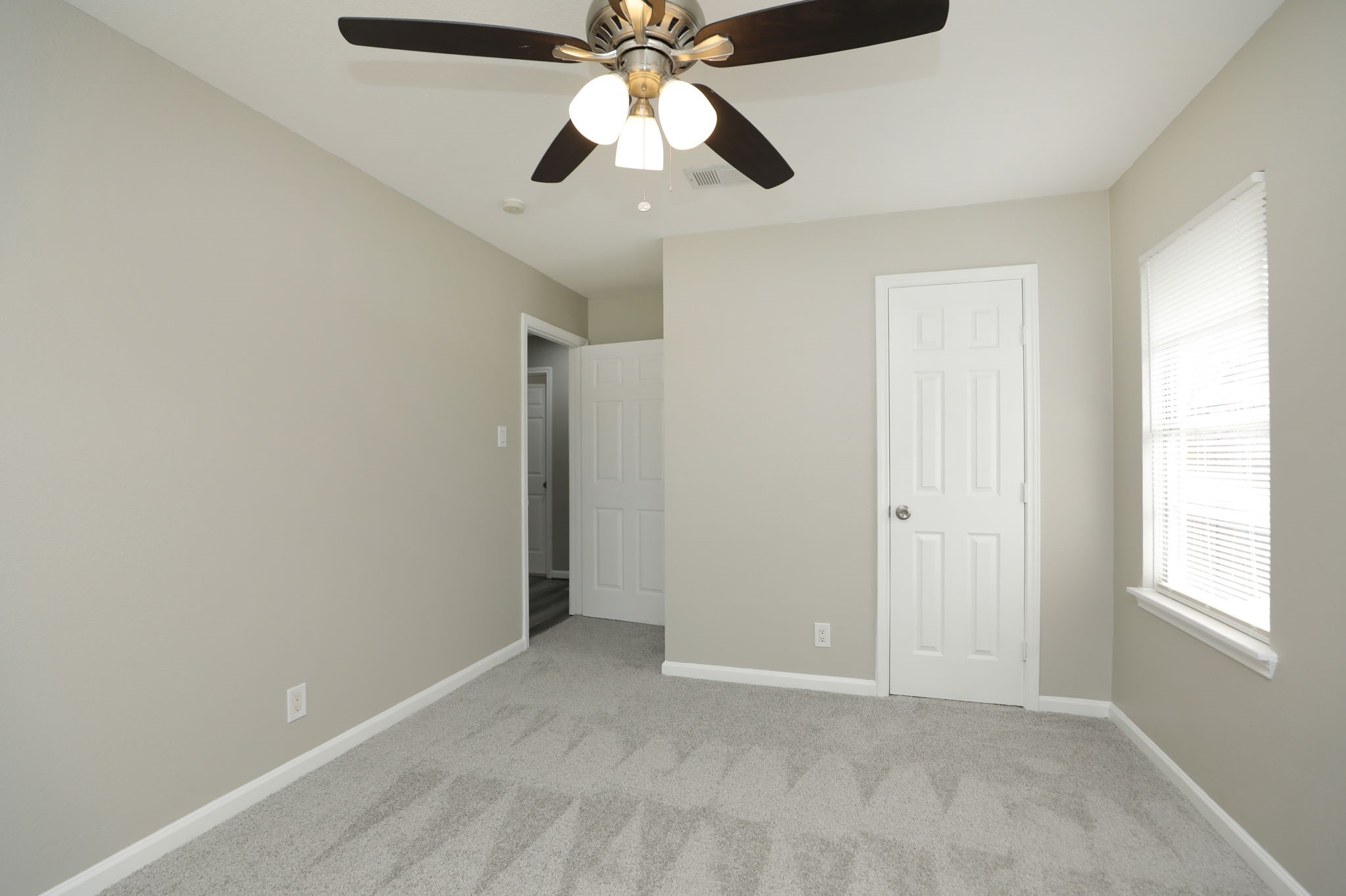 9211 Vinearbor Street Houston, TX 77033 - Photo 23 of 33 a view of an empty room and window with a ceiling fan