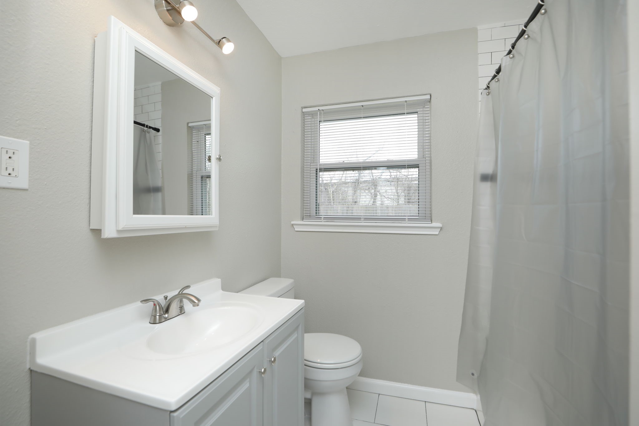 9211 Vinearbor Street Houston, TX 77033 - Photo 26 of 33 a bathroom with a sink toilet and a mirror