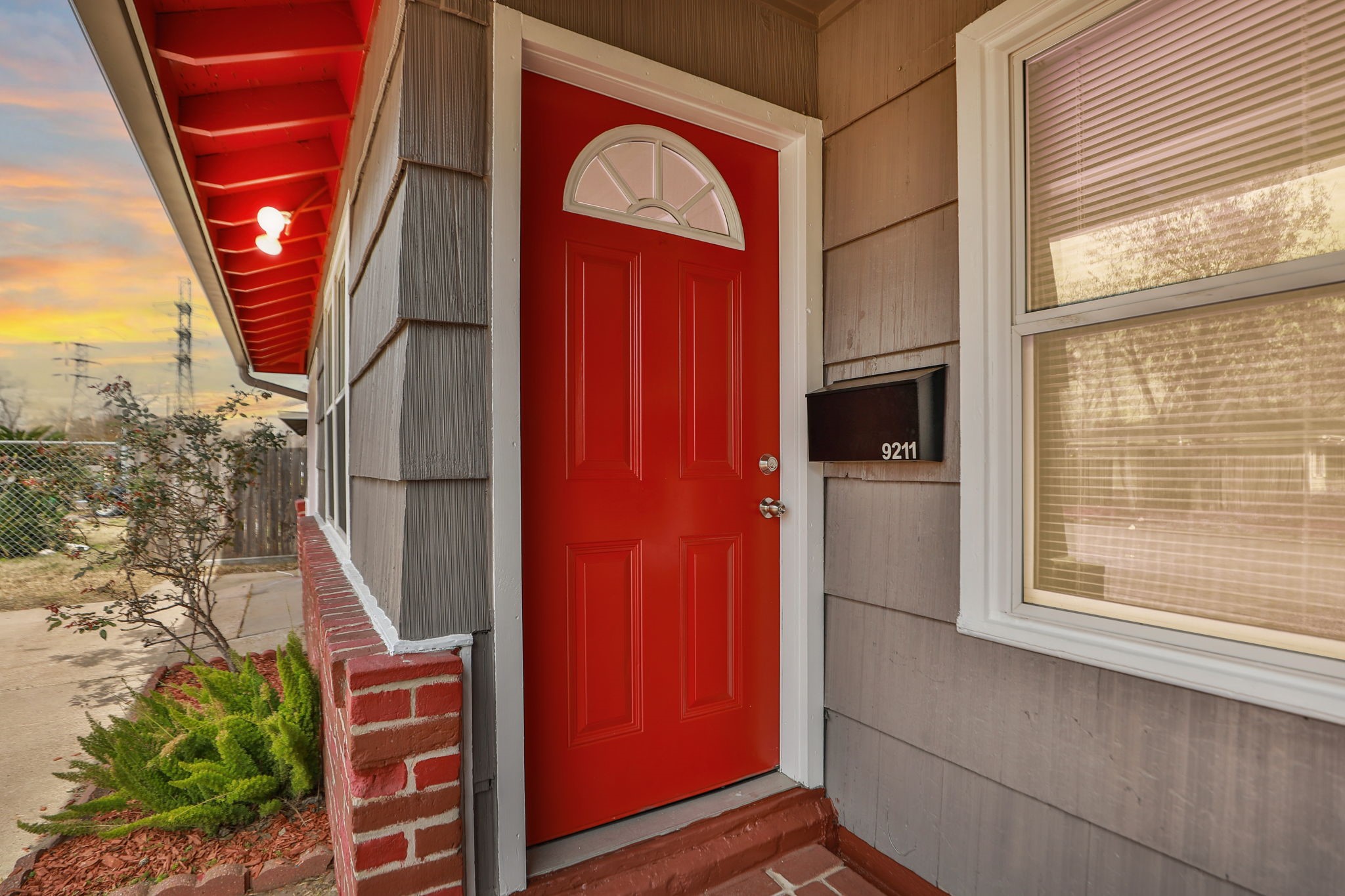 9211 Vinearbor Street Houston, TX 77033 - Photo 4 of 33 a front view of a house with a red door and a potted plant