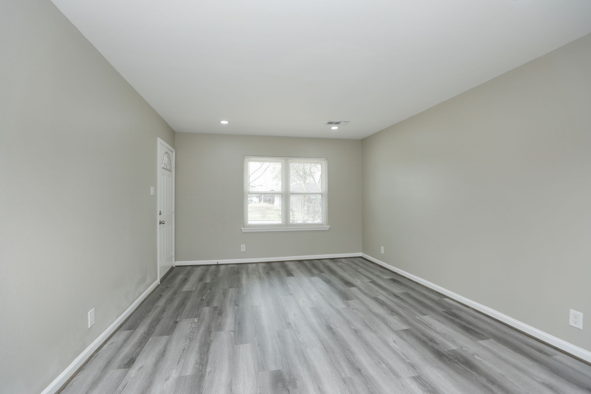 9211 Vinearbor Street Houston, TX 77033 - Photo 8 of 33 an empty room with wooden floor and windows