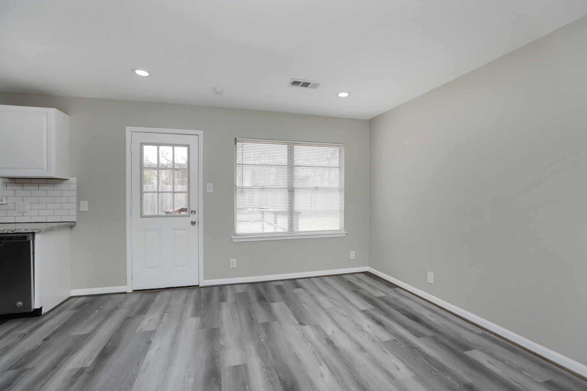 9211 Vinearbor Street Houston, TX 77033 - Photo 9 of 33 an empty room with wooden floor and windows