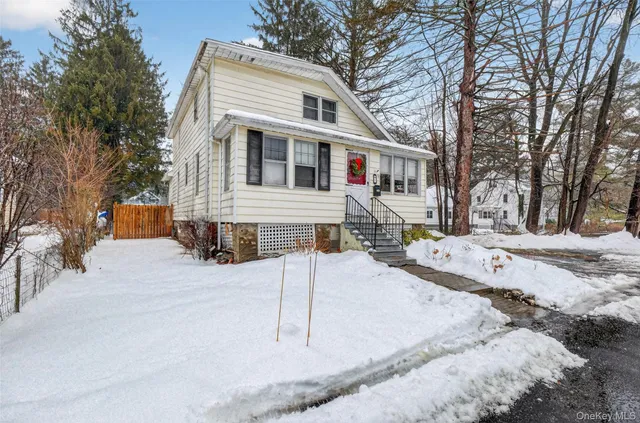 a front view of a house with a yard covered in snow