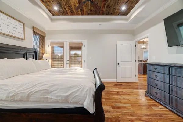 a spacious bedroom with a bed and a flat screen tv