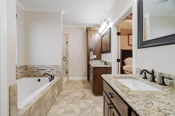 a bathroom with a granite countertop tub sink and mirror