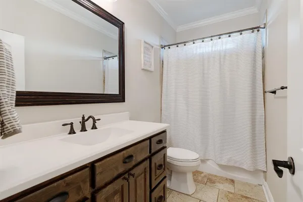 a bathroom with a sink a toilet a mirror and shower curtain