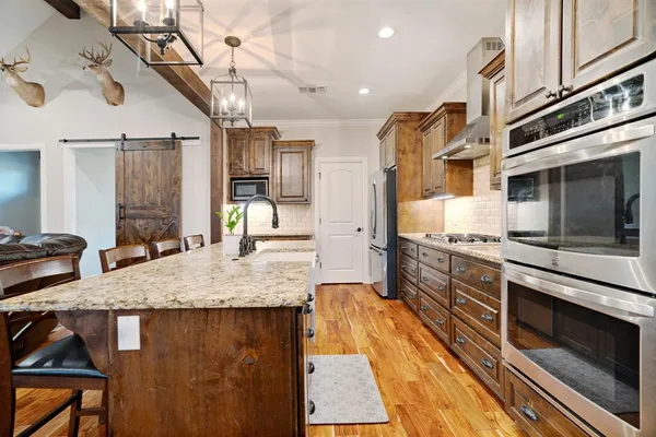 a large kitchen with stainless steel appliances granite countertop a stove and a sink