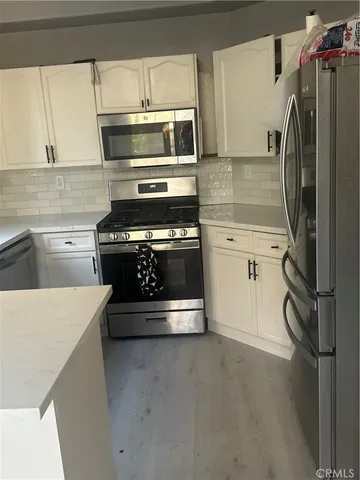 a kitchen with granite countertop a stove and a refrigerator