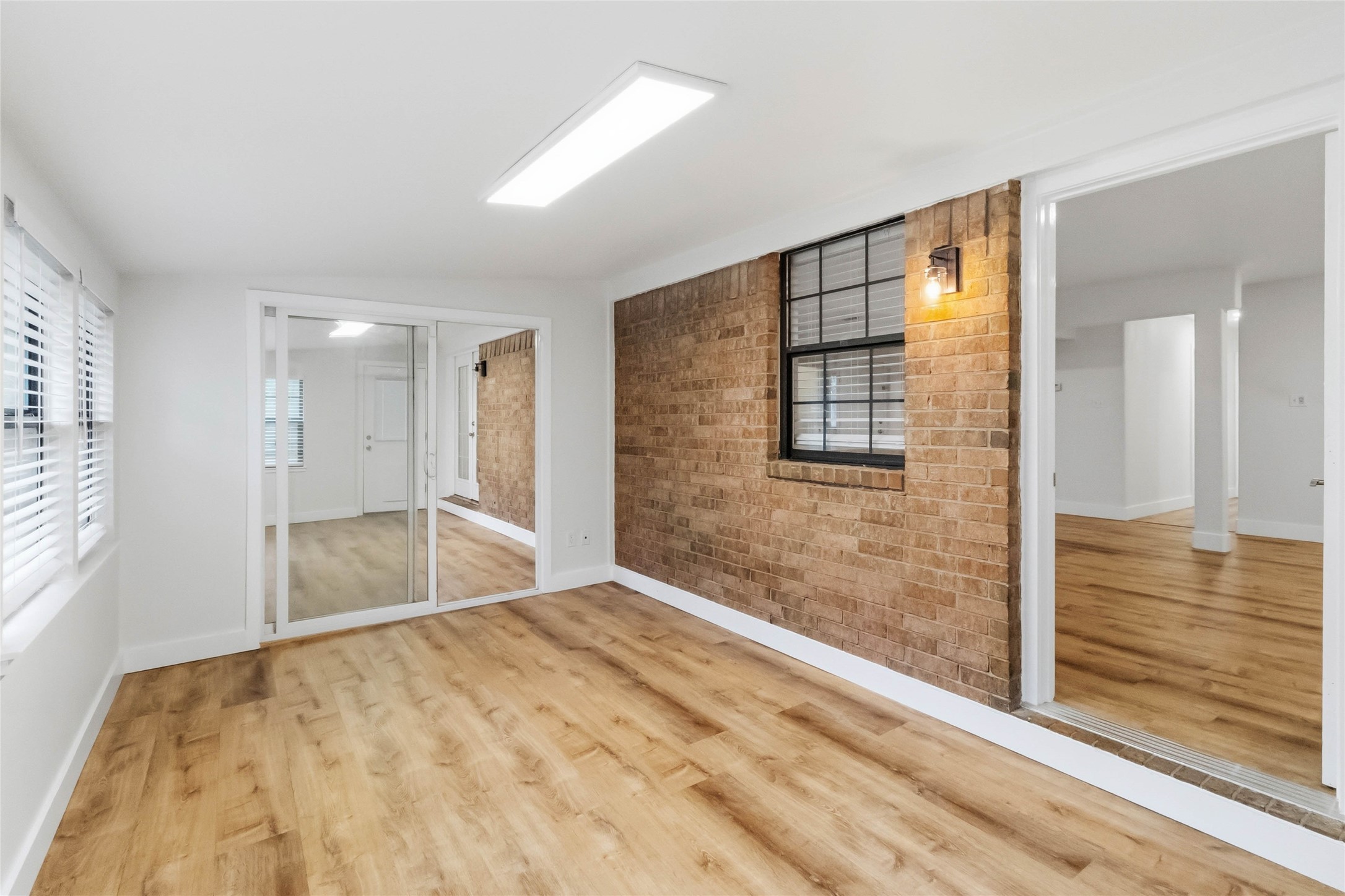 326 Pine View Loop Bastrop, TX 78602 - Photo 22 of 30 A well-lit interior space with brick accents and wide plank flooring awaits personalization.