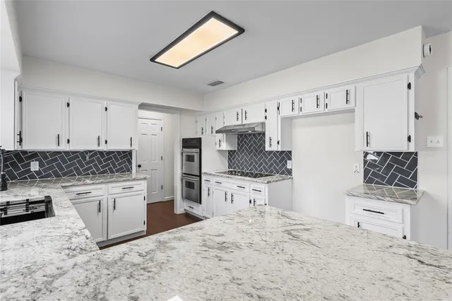 a kitchen with stainless steel appliances a stove a sink and a refrigerator