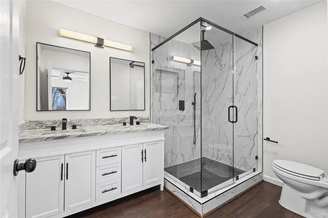 a bathroom with a shower sink mirror and toilet