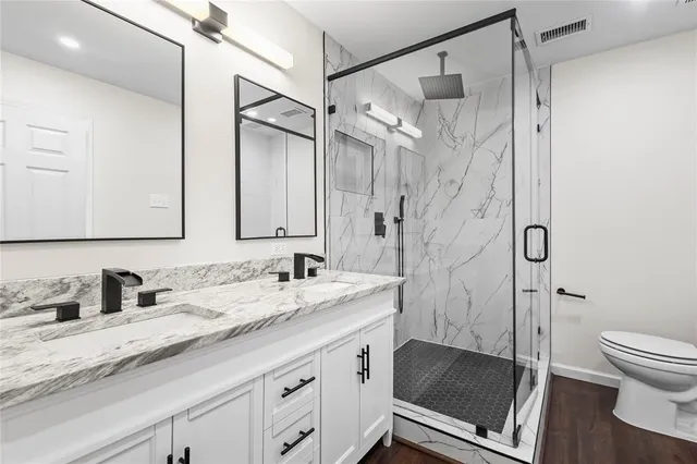 a bathroom with a granite countertop sink toilet and shower