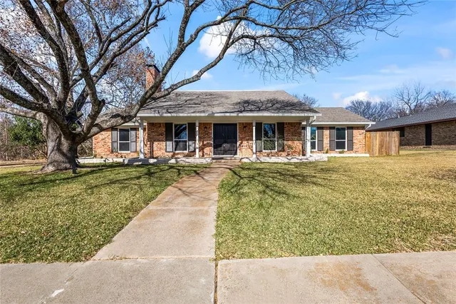 a front view of house with yard slide and large trees