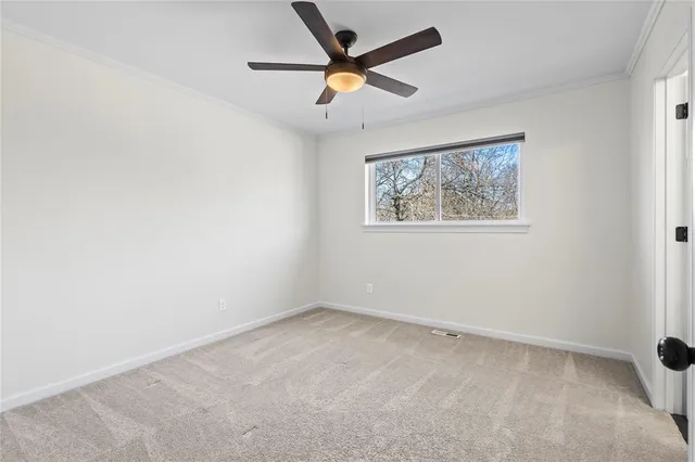 an empty room with a window and a fan