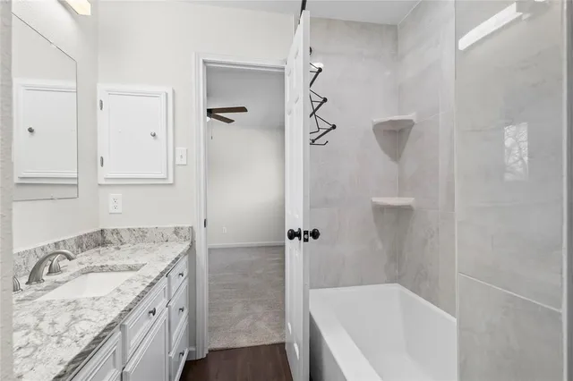 a bathroom with a granite countertop sink a shower and a mirror