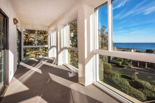 a view of a porch with a floor to ceiling window and wooden floor
