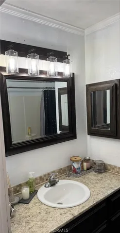 a bathroom with a granite countertop sink a mirror a vanity and toilet
