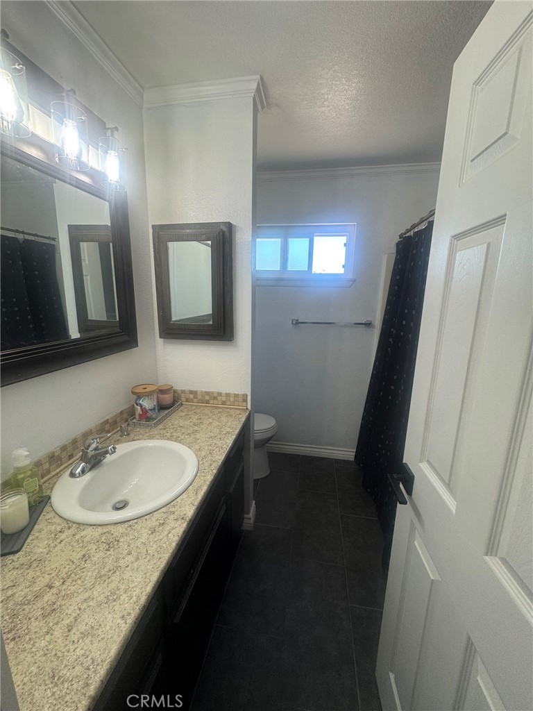 13771 Wawona Road Apple Valley, CA 92307 - Photo 15 of 30 a bathroom with a granite countertop sink a mirror a vanity and toilet