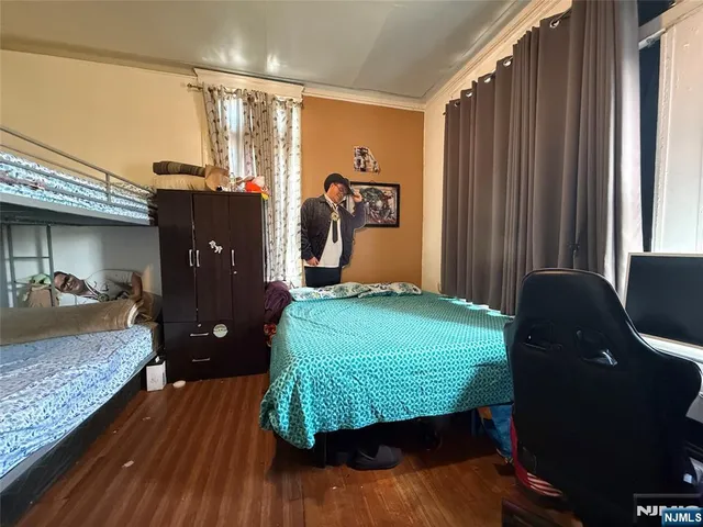a bedroom with a bed and wooden floor