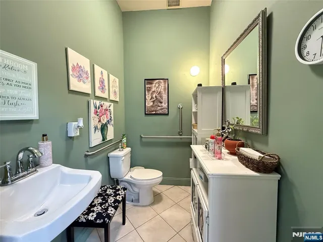 a bathroom with a sink vanity mirror and toilet