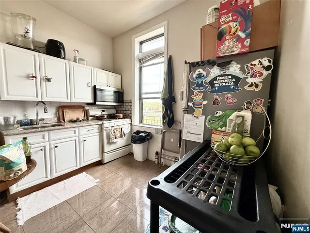 a kitchen with stainless steel appliances a stove a sink and a cabinets